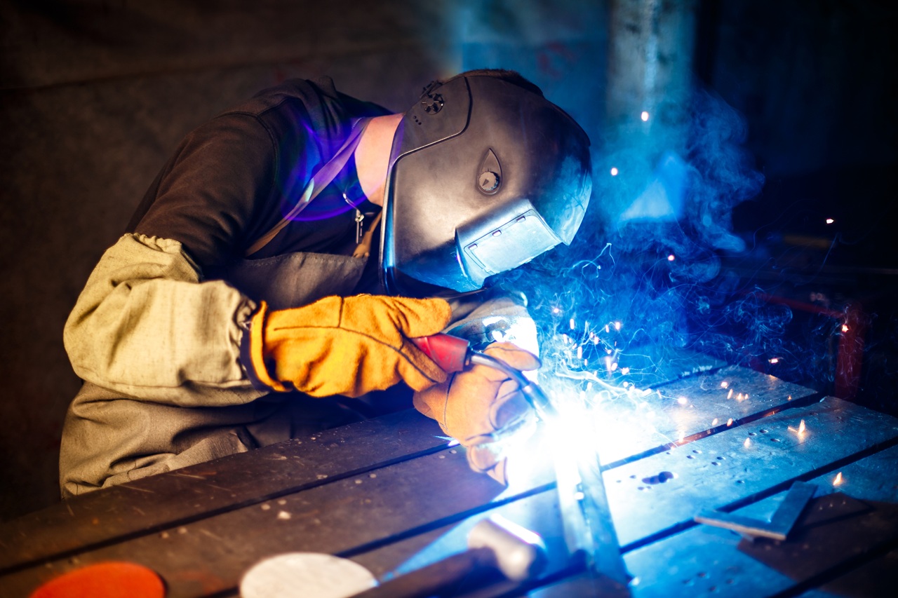 Worker cutting metal with plasma equipment. on plant